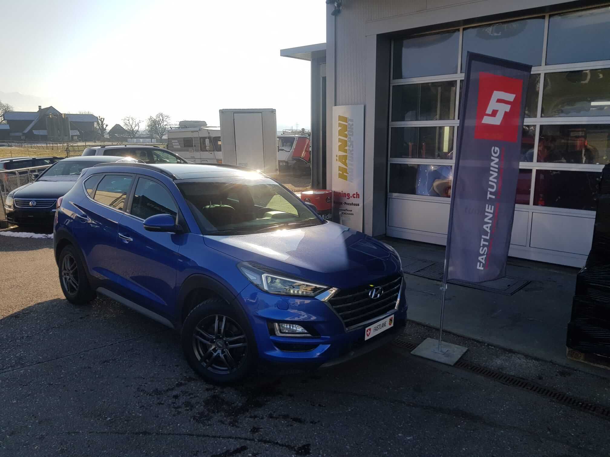 Ein blauer Hyundai Tucson 1.6 T-GDI steht vor der Garage von Fastlane Tuning Schweiz