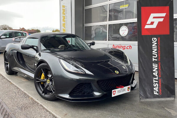 Ein schwarzer Lotus Exige Sport 350 steht neben dem Banner der Fastlane Tuning Schweiz GmbH