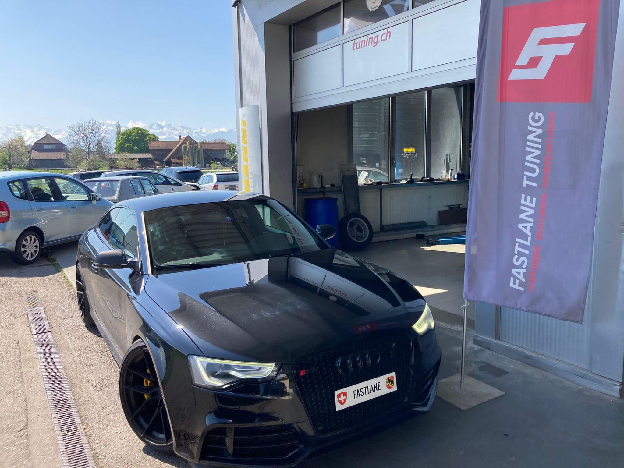 in schwarzer Audi RS5 Performance steht neben der Fastlane Tuning Schwiez Flagge