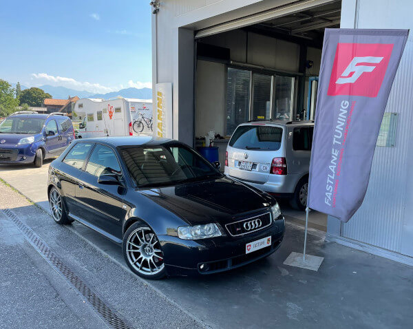 Ein schwarze Audi S3 8L 1.8T steht neben das Fastlane Tuning Schweiz Flagge