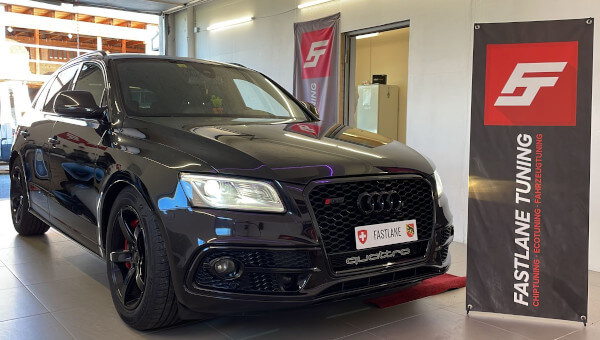 Ein schwarze Audi SQ5 3.0 TDI V6 steht neben das Fastlane Tuning Schweiz GmbH banner