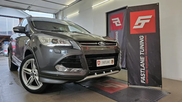 Ein grauer Ford Kuga steht neben dem Banner der Fastlane Tuning Schweiz GmbH