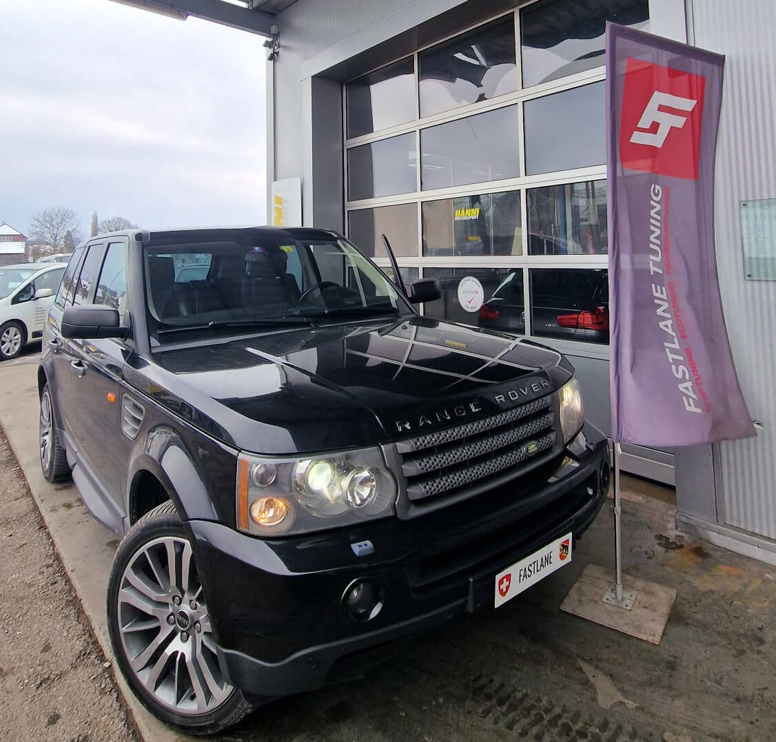 Ein schwarzer Range Rover Sport 2.7 V6 TDI steht neben der Fastlane Tuning Schweiz Flagge