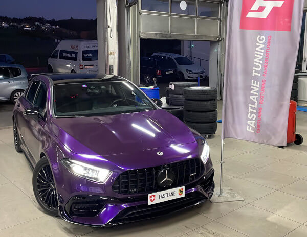 Ein lila Mercedes A 45 AMG S steht neben der Fastlane Tuning Schweiz Flagge in der Garage