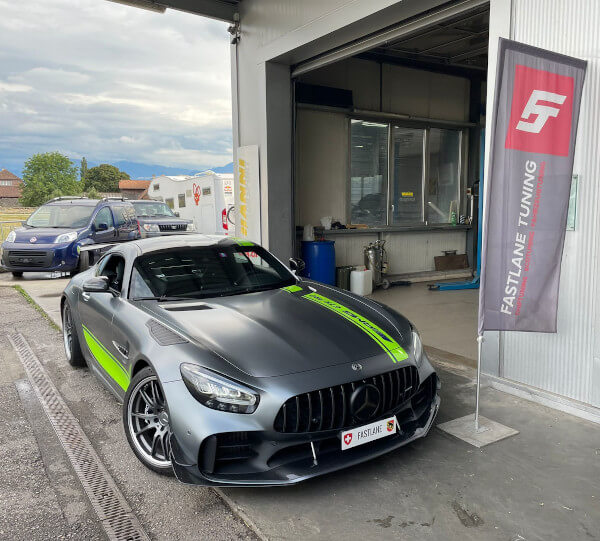 Ein mattgrauer Mercedes AMG GTR Pro Edition steht neben der Fastlane Tuning Schweiz Flagge.