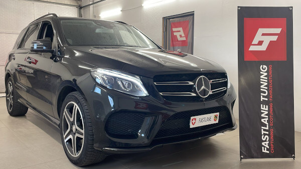 Ein schwarze Mercedes Benz GLE 400 steht neben das Fastlane Tuning Schweiz GmbH banner