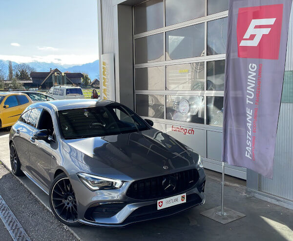 Ein grau Mercedes CLA 35 AMG Shooting Brake steht neben das Fastlane Tuning Schweiz Flagge