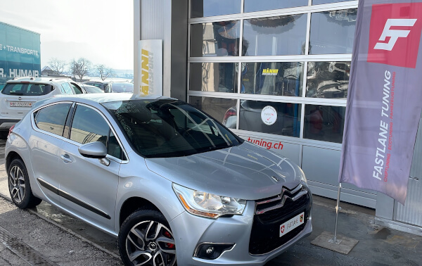 Ein silberner Citroen DS3 steht neben der Fastlane Tuning Schweiz Flagge.