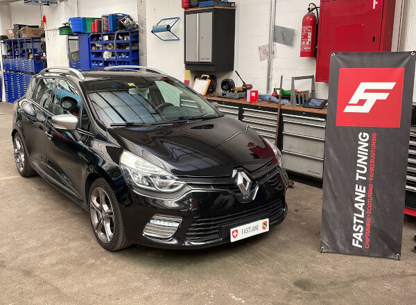 Ein schwarzer Renault Clio IV GT steht neben dem Banner der Fastlane Tuning Schweiz GmbH