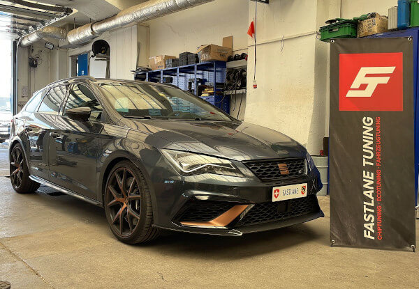 Ein schwarzer SEAT Cupra ST300 steht neben dem Banner der Fastlane Tuning Schweiz GmbH.