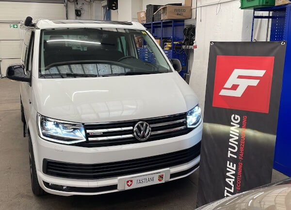 Ein weisse VW T6 Beach 2.0 TDI steht beim den Fastlane Tuning Schweiz GmbH flagge