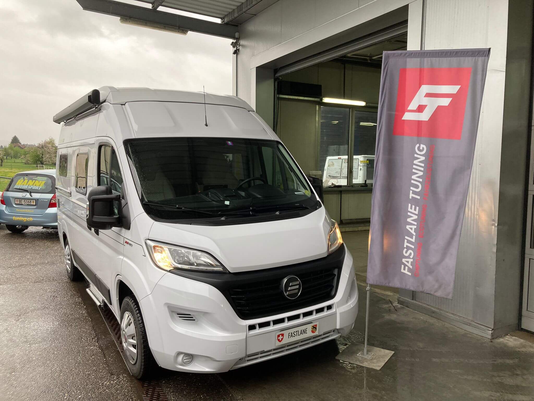 Ein weißes Fiat Ducato-Wohnmobil steht neben der schnellen letzten Flagge